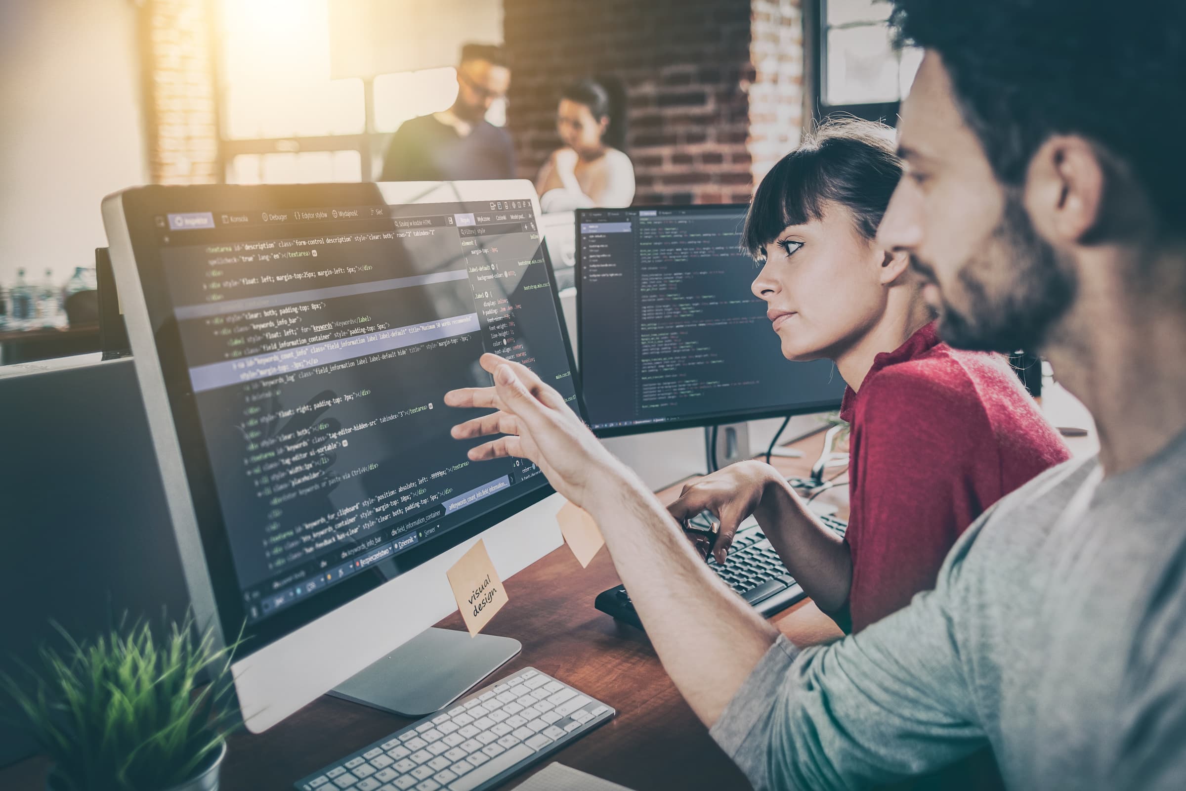 Web developers looking at a monitor with code