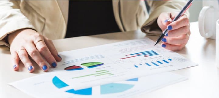 A person reviewing printed charts with a pen