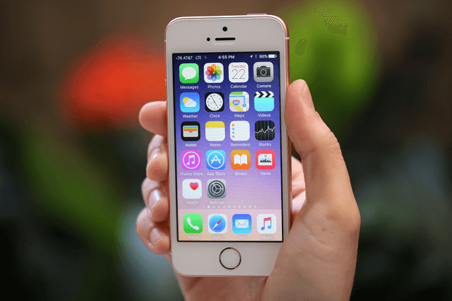 Person holding iphone with home page apps