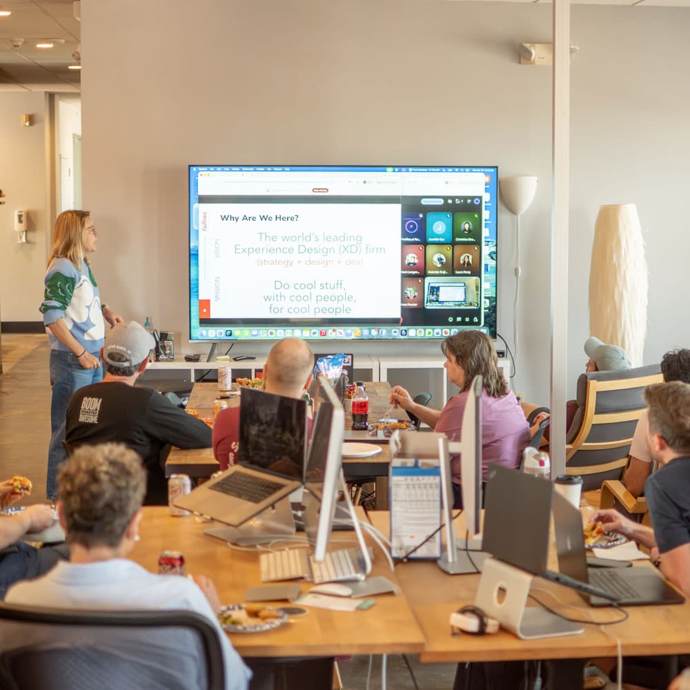 A team presentation on a large screen in the IntegrityXD office