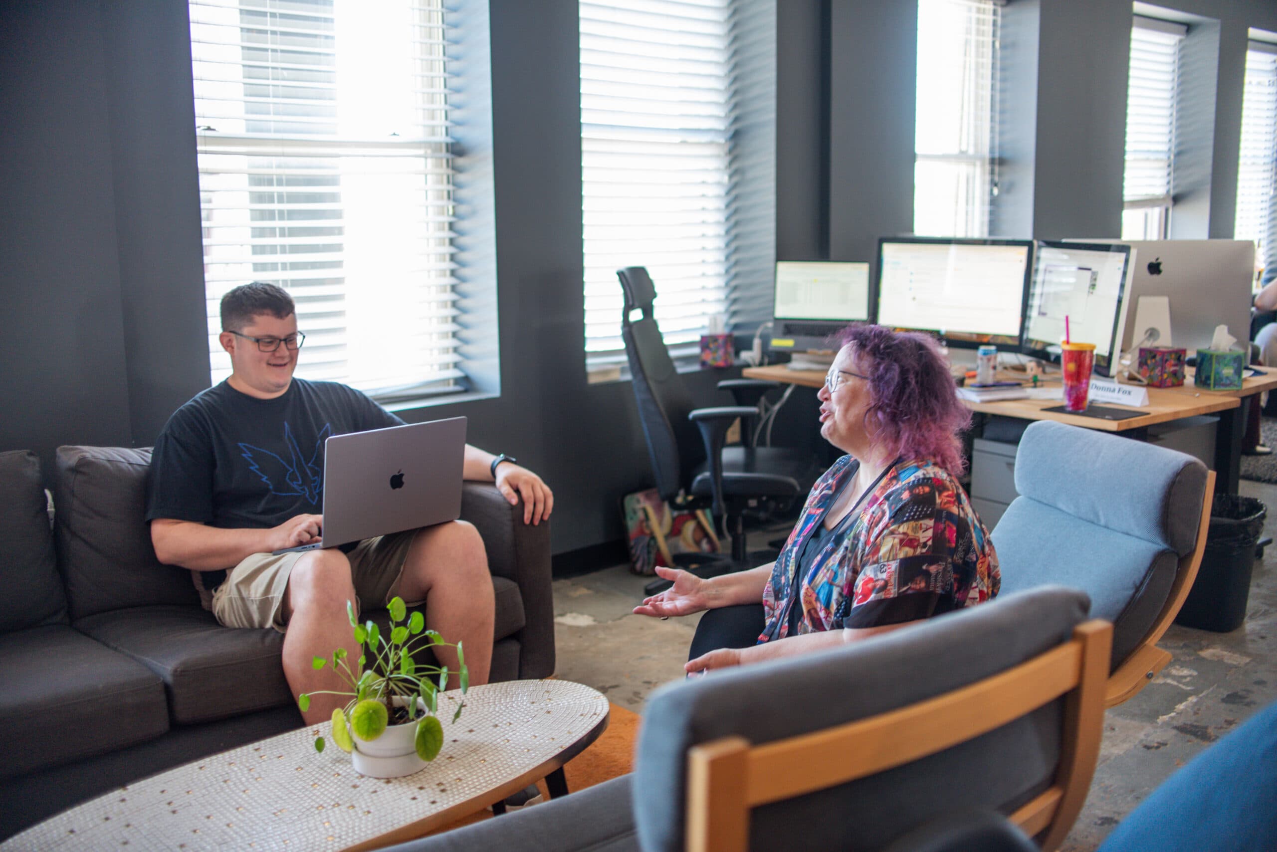 Two team members talking on couches in the office lounge