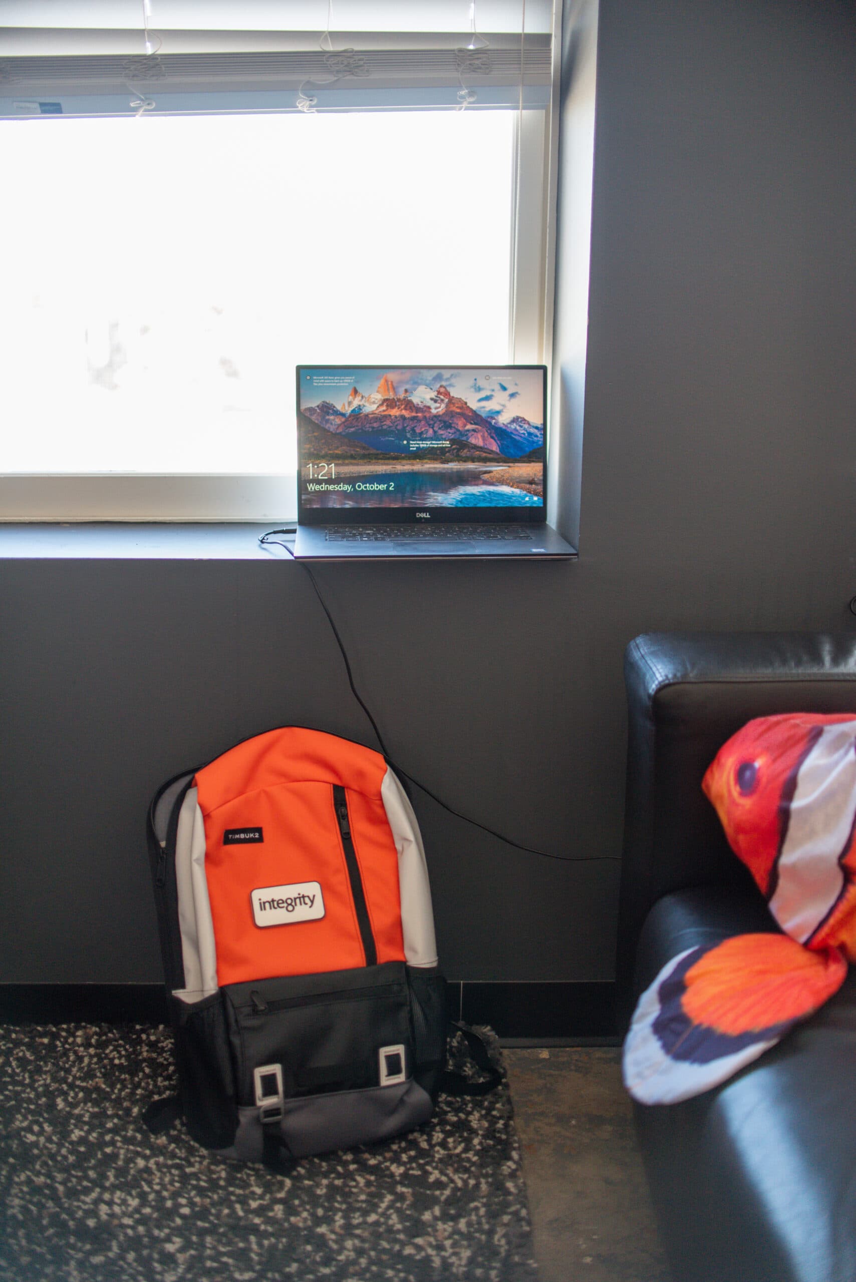 An orange integrity backpack on the office floor