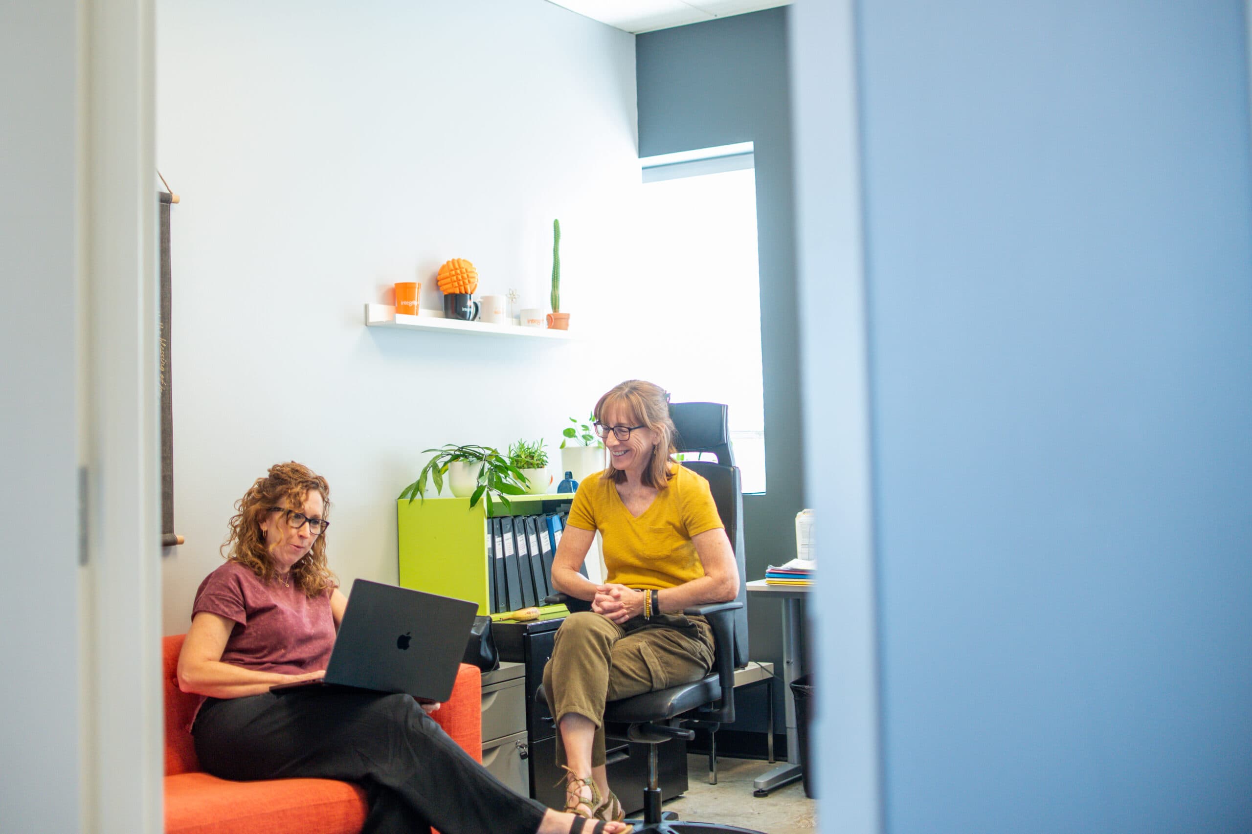 Integrity St Louis employees collaborating in office with orange chair